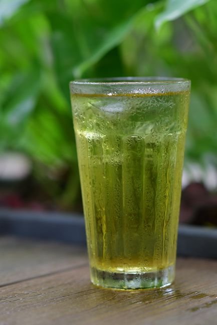 Taza de té verde con hojas frescas, antioxidante natural para la salud glucémica
